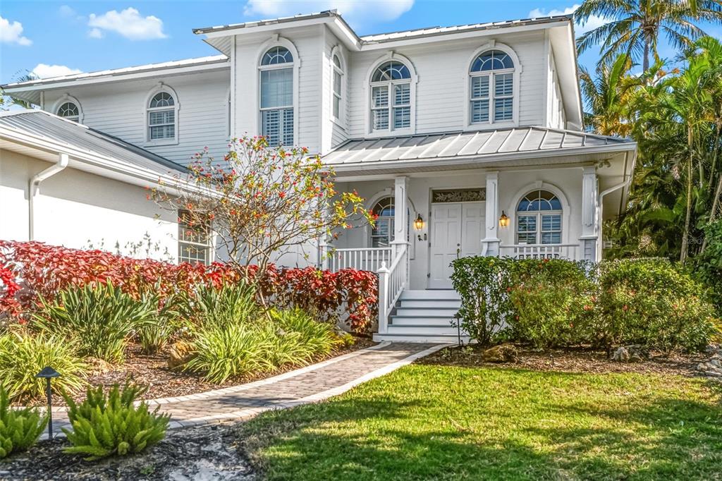 5382 Sandhamn Place Longboat Key, FL 34228 - Photo 2 of 55 front view of a house with a yard