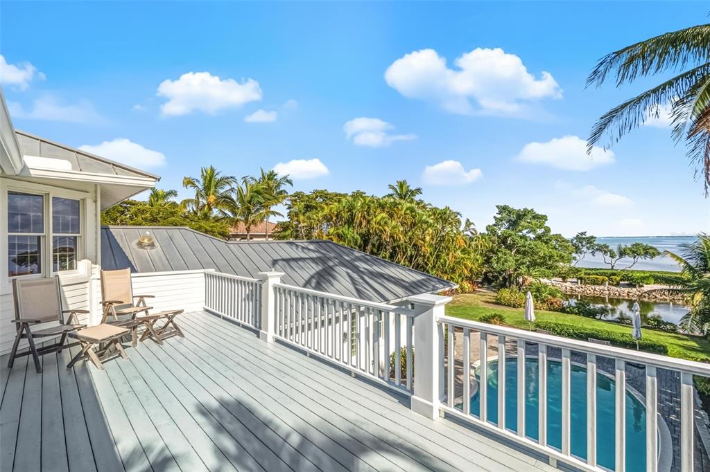 5382 Sandhamn Place Longboat Key, FL 34228 - Photo 32 of 55 a view of a balcony with wooden floor and iron fence