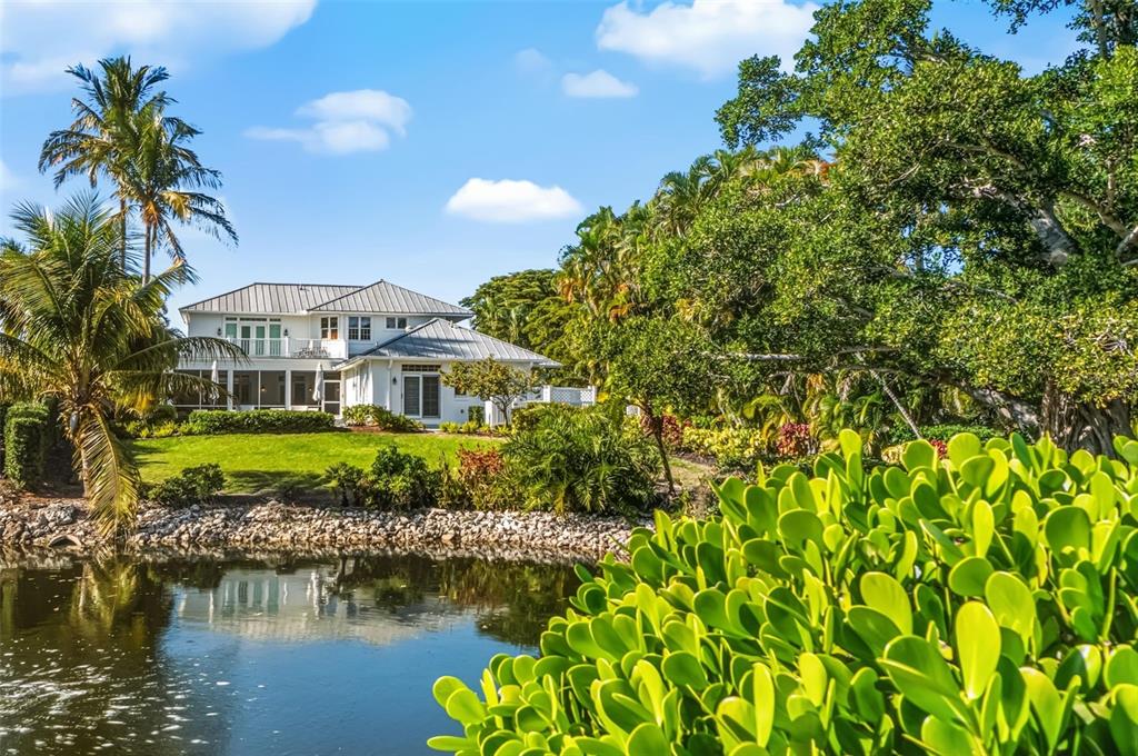 5382 Sandhamn Place Longboat Key, FL 34228 - Photo 43 of 55 a front view of a house with a garden
