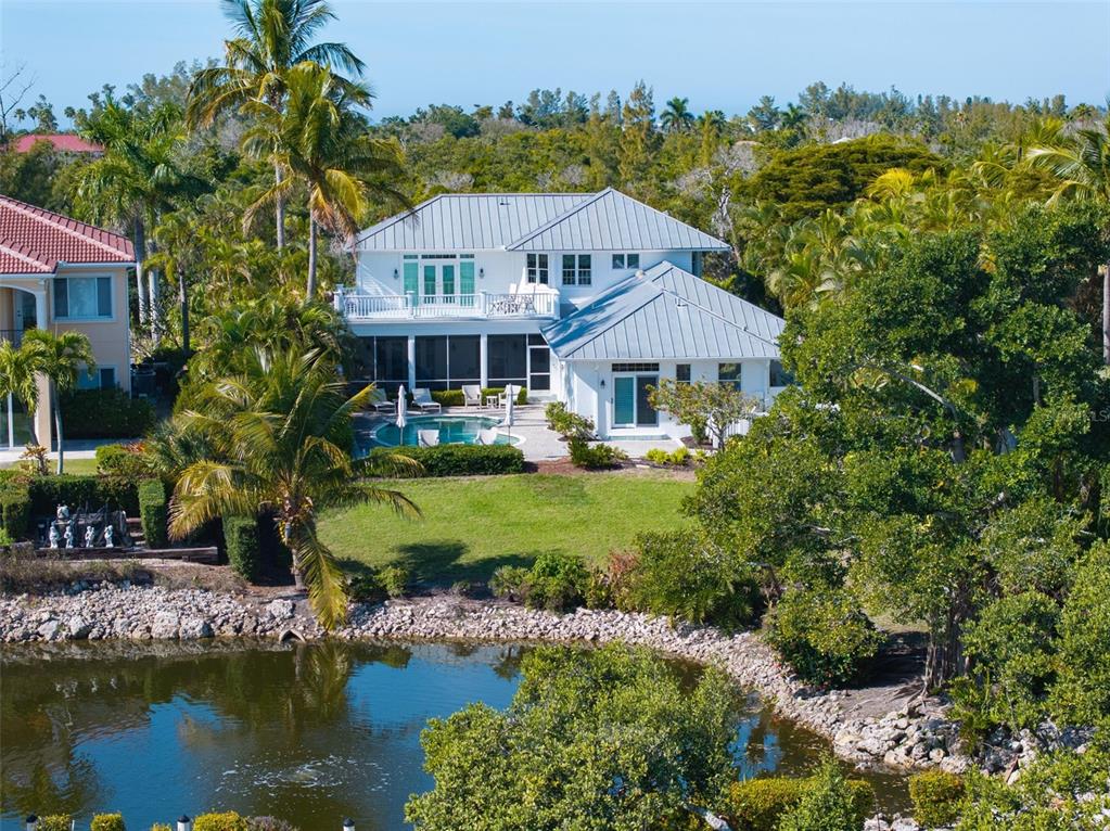 5382 Sandhamn Place Longboat Key, FL 34228 - Photo 52 of 55 a aerial view of a house with a garden and lake view