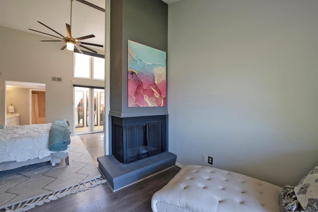 3915 Roma Court Rockwall, TX 75087 - Photo 21 of 40 Living room with a high ceiling, wood finished floors, a multi sided fireplace, and a ceiling fan