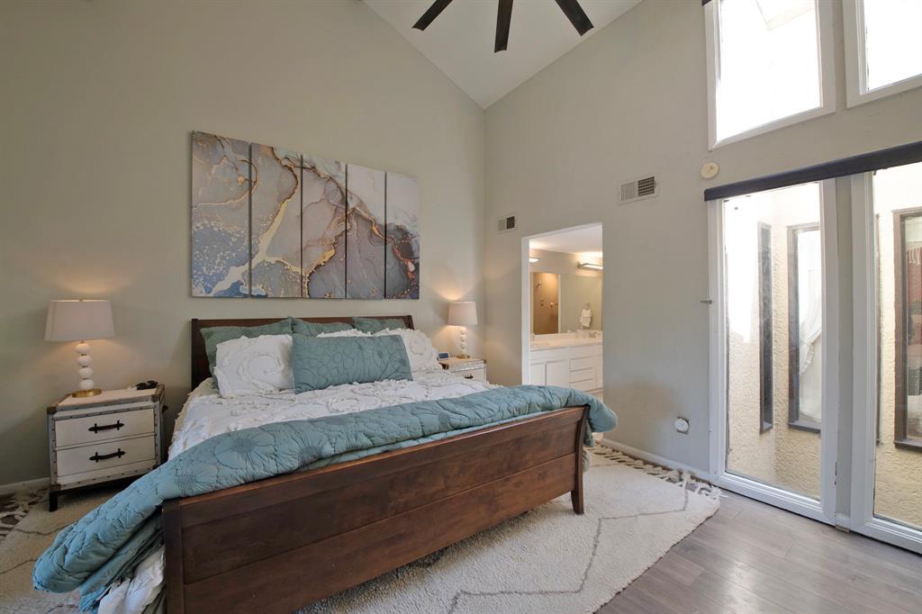 3915 Roma Court Rockwall, TX 75087 - Photo 23 of 40 Bedroom featuring wood finished floors, high vaulted ceiling, access to outside, a ceiling fan, and ensuite bathroom