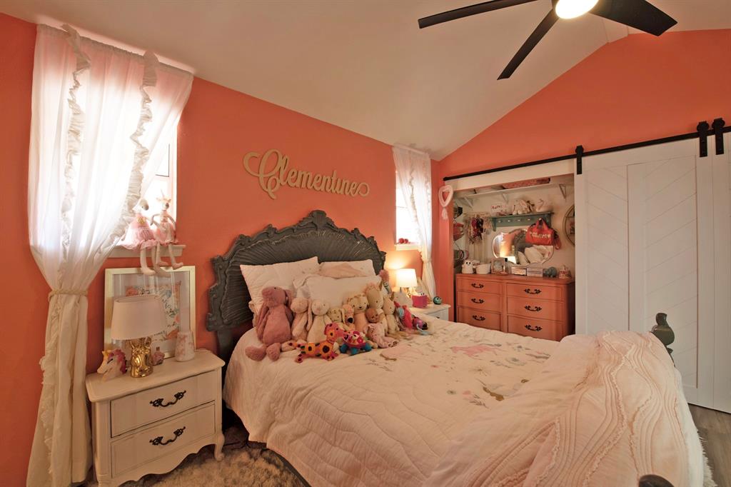 3915 Roma Court Rockwall, TX 75087 - Photo 29 of 40 Bedroom with a barn door, vaulted ceiling, and ceiling fan