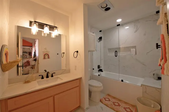 a spacious bathroom with a bathtub shower sink mirror vanity and toilet