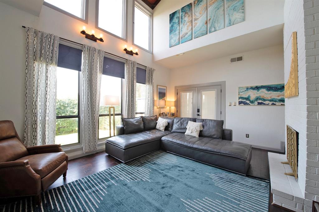 3915 Roma Court Rockwall, TX 75087 - Photo 3 of 40 Living room with dark wood-type flooring, a fireplace, french doors, and a towering ceiling