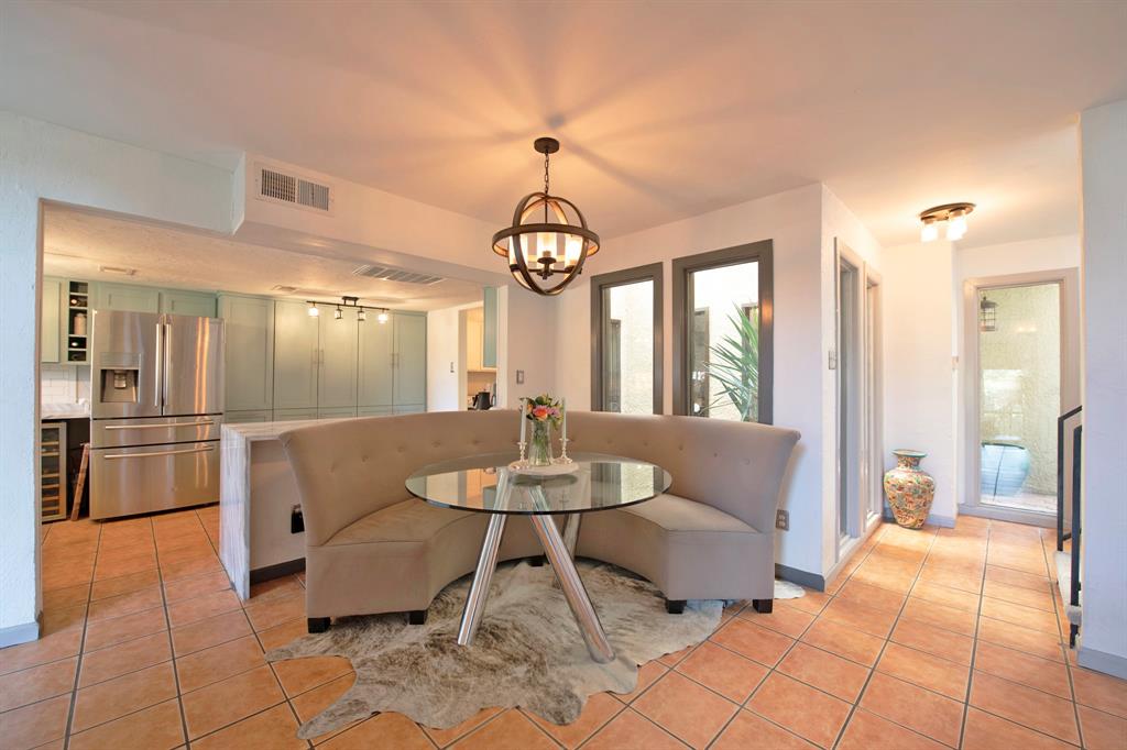 3915 Roma Court Rockwall, TX 75087 - Photo 6 of 40 Dining room featuring light tile patterned floors, wine cooler, and a chandelier