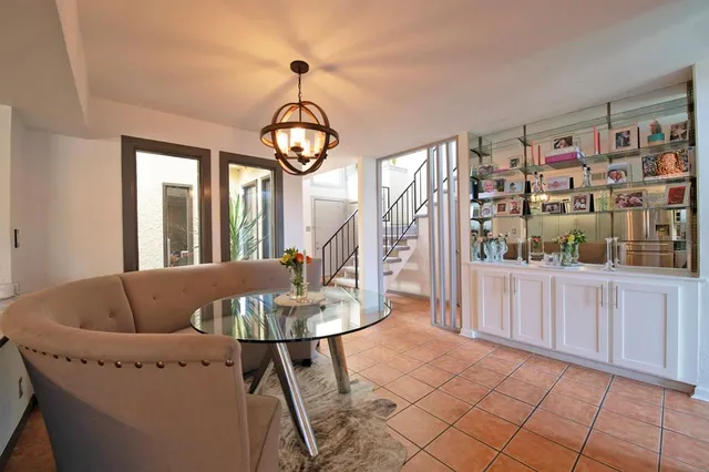 a living room with furniture a dining table and a large window