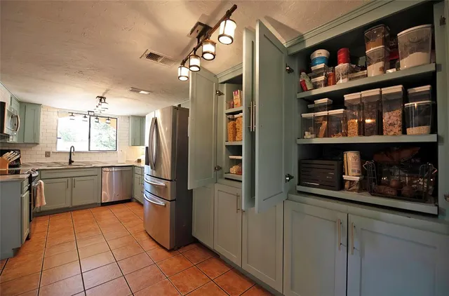 a kitchen with stainless steel appliances granite countertop a refrigerator and a sink