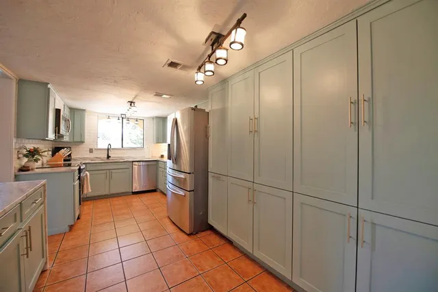 a kitchen with a refrigerator a sink and cabinets