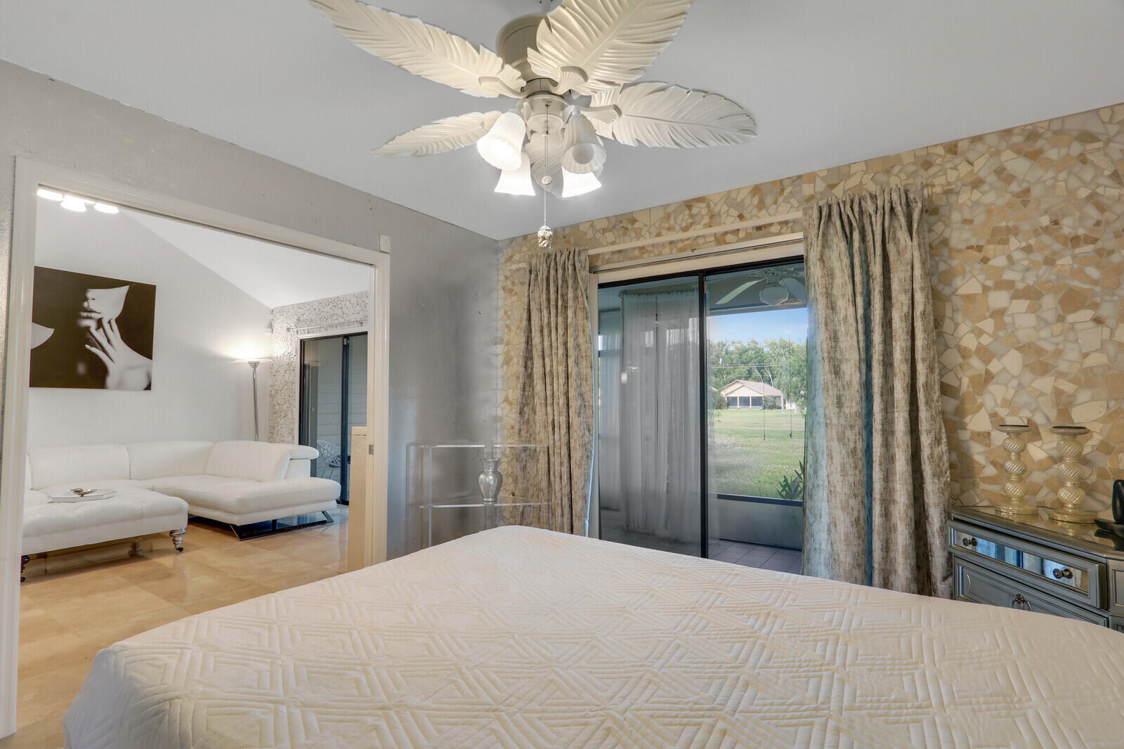 6136 Southeast Georgetown Place Hobe Sound, FL 33455 - Photo 16 of 46 a bedroom with a bed and a chandelier