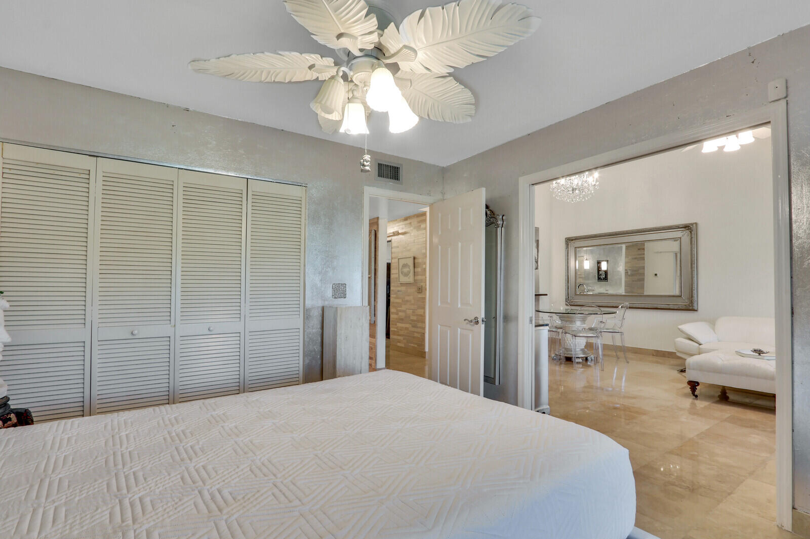 6136 Southeast Georgetown Place Hobe Sound, FL 33455 - Photo 17 of 46 a bedroom with a bed and a chandelier