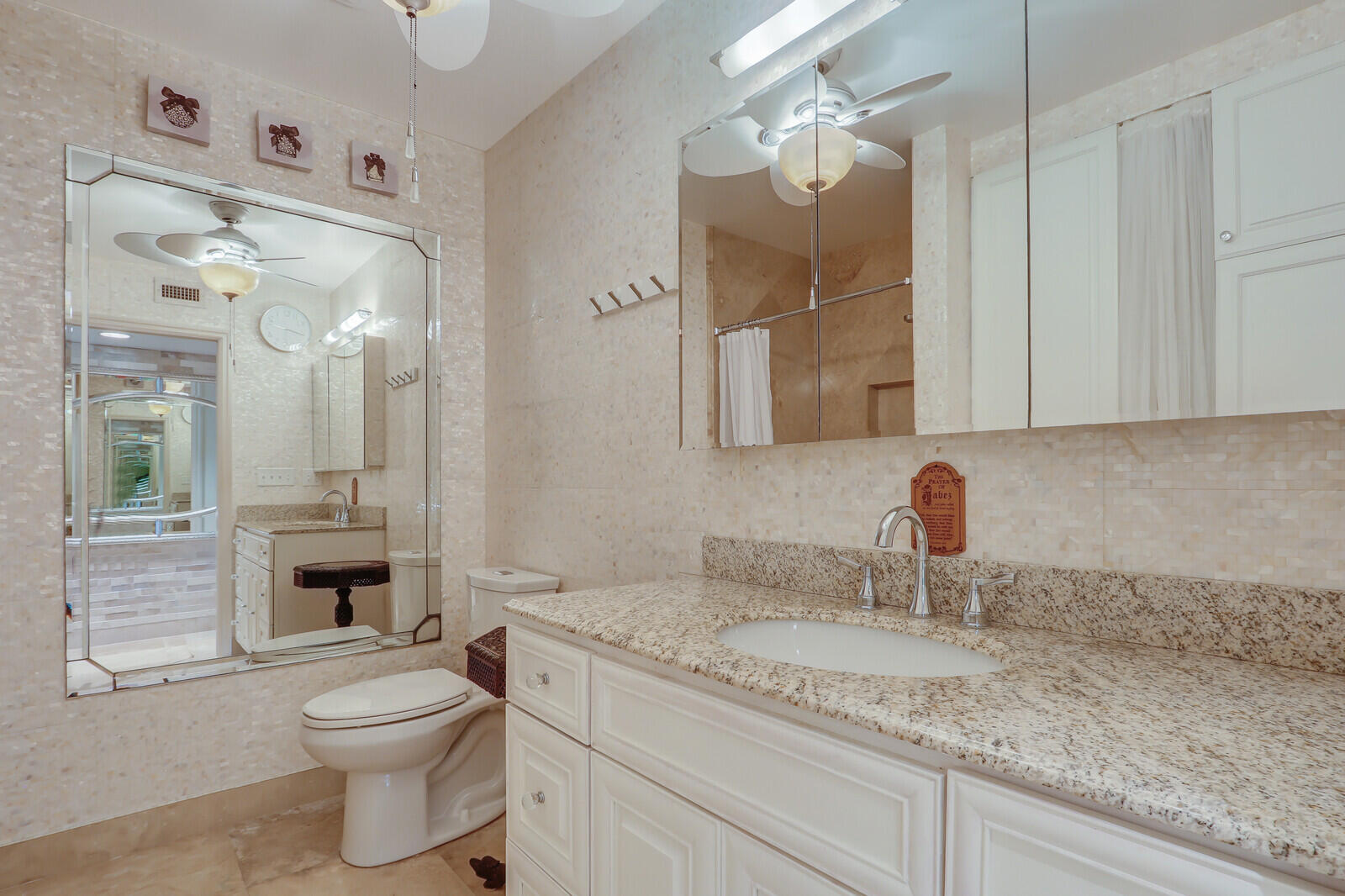 6136 Southeast Georgetown Place Hobe Sound, FL 33455 - Photo 18 of 46 a bathroom with a granite countertop sink a toilet and a mirror