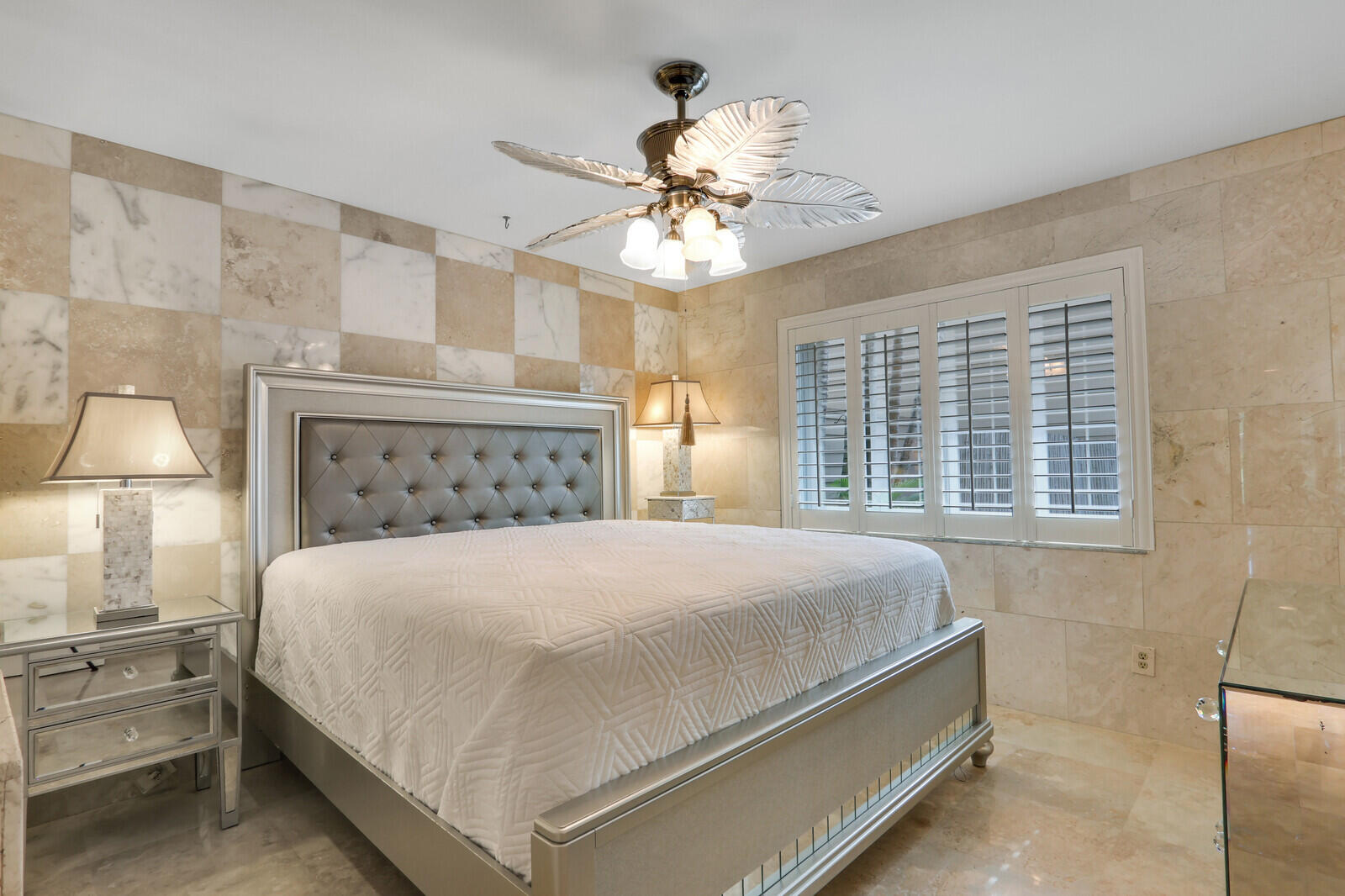 6136 Southeast Georgetown Place Hobe Sound, FL 33455 - Photo 20 of 46 a bedroom with a large bed and a chandelier fan