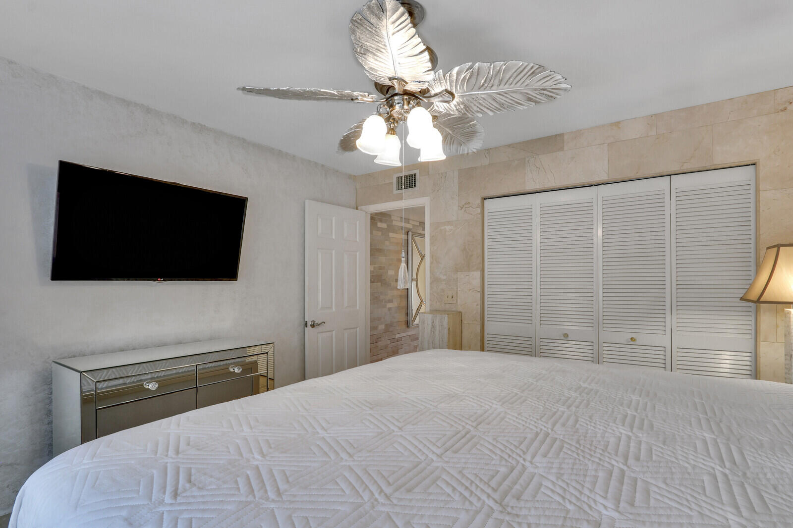 6136 Southeast Georgetown Place Hobe Sound, FL 33455 - Photo 21 of 46 a bedroom with a bed and a flat screen tv