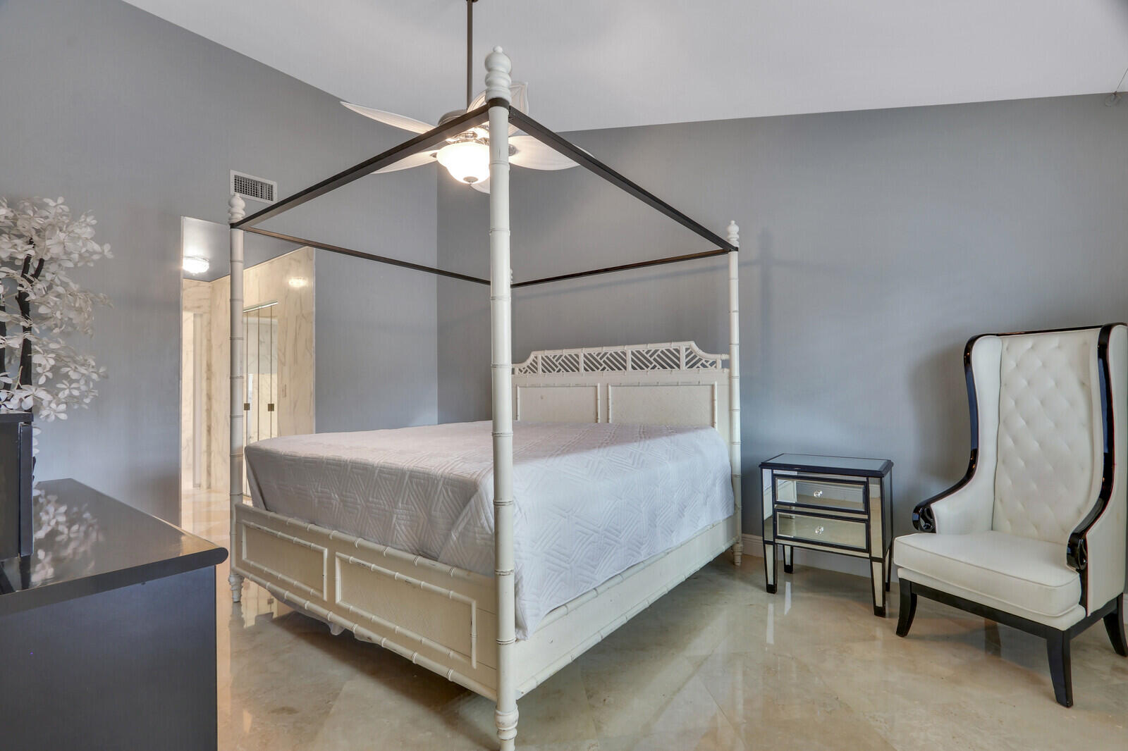 6136 Southeast Georgetown Place Hobe Sound, FL 33455 - Photo 26 of 46 a bedroom with a bed and a chair