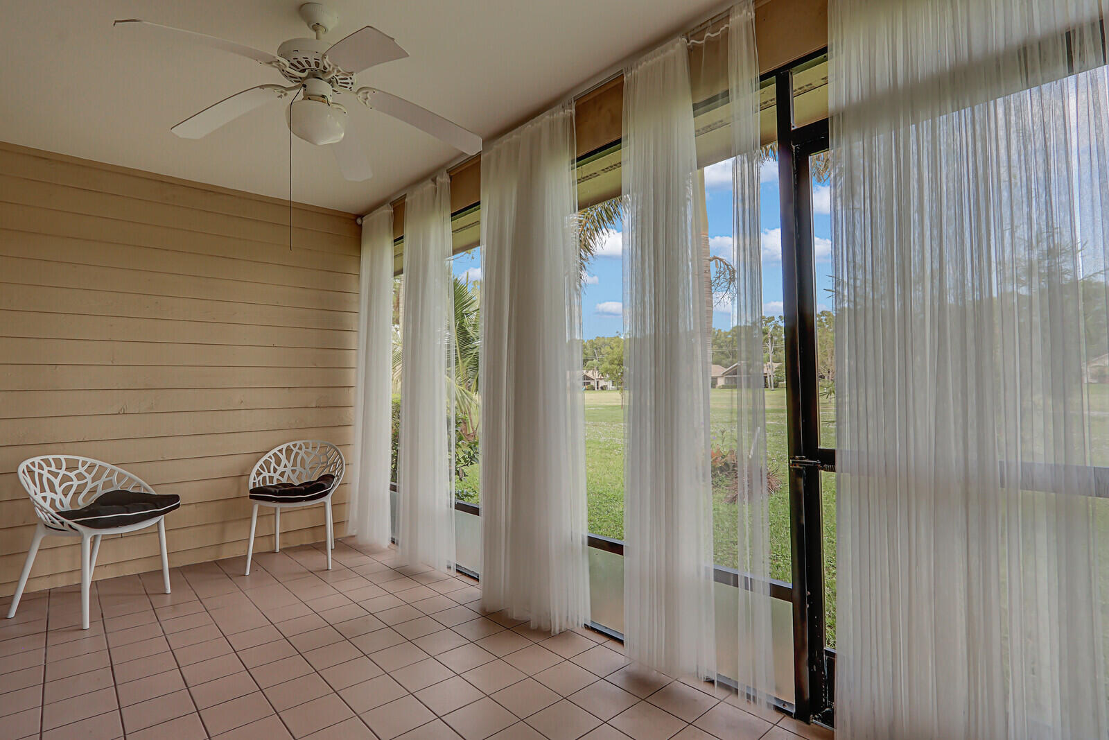 6136 Southeast Georgetown Place Hobe Sound, FL 33455 - Photo 34 of 46 a view of a hallway with chairs and a refrigerator