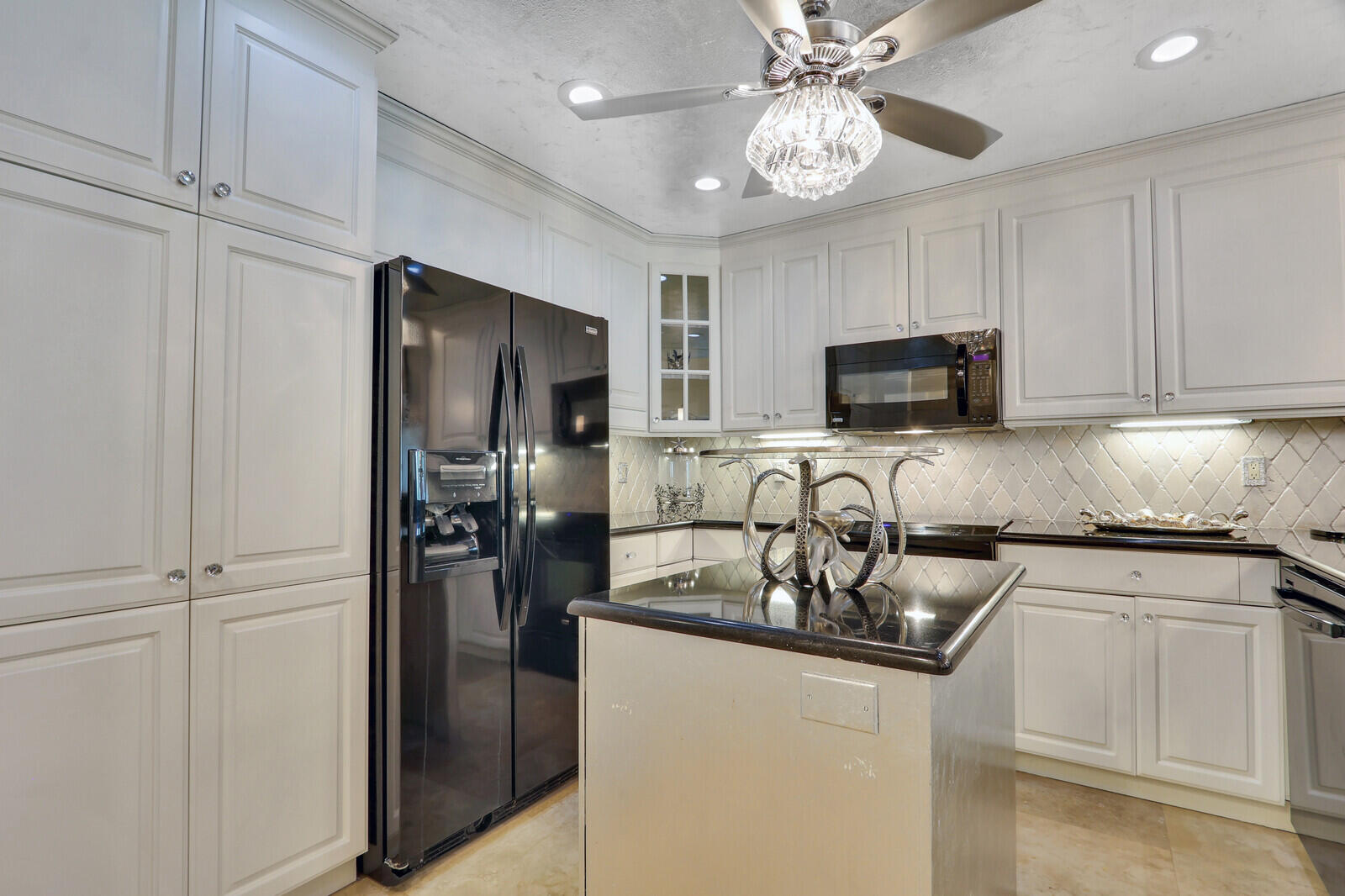 6136 Southeast Georgetown Place Hobe Sound, FL 33455 - Photo 6 of 46 a kitchen with stainless steel appliances granite countertop a refrigerator a stove a microwave oven a sink with island and chairs