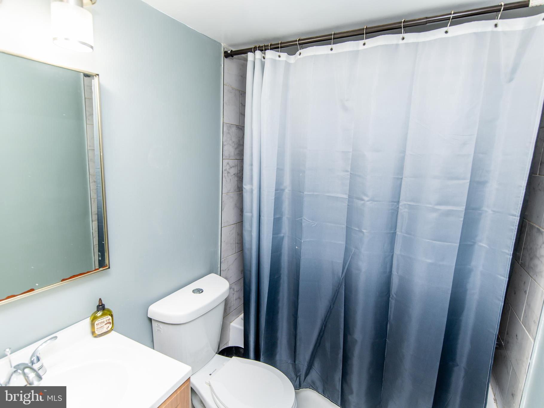 3934 Bel Pre Road, Unit 39342 Silver Spring, MD 20906 - Photo 12 of 30 a white toilet sitting next to a shower curtain