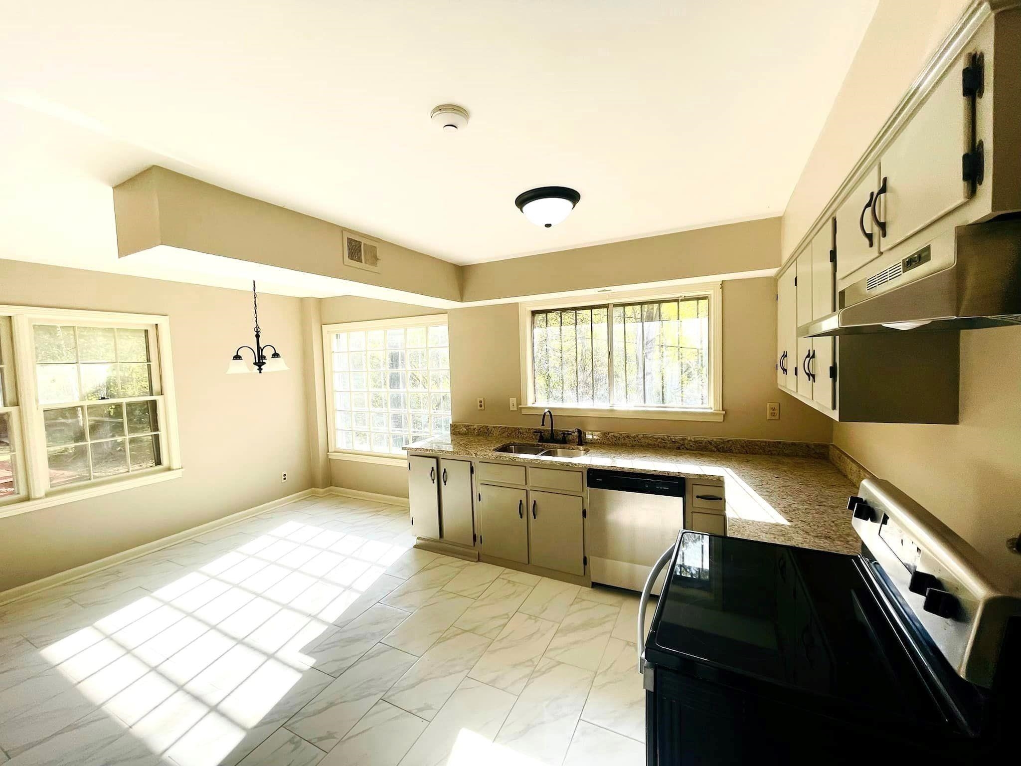 3013 Dumbarton Road Memphis, TN 38128 - Photo 4 of 7 a large white kitchen with granite countertop a stove a sink and a refrigerator