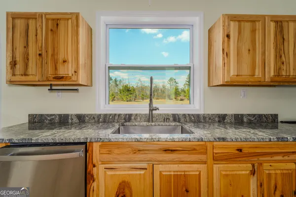 a kitchen with granite countertop stainless steel appliances granite countertop a sink and cabinets