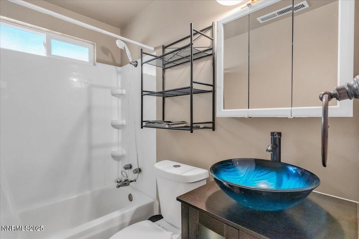 1231 Manhattan Way Gardnerville, NV 89460 - Photo 17 of 45 a bathroom with a sink toilet a mirror and shower