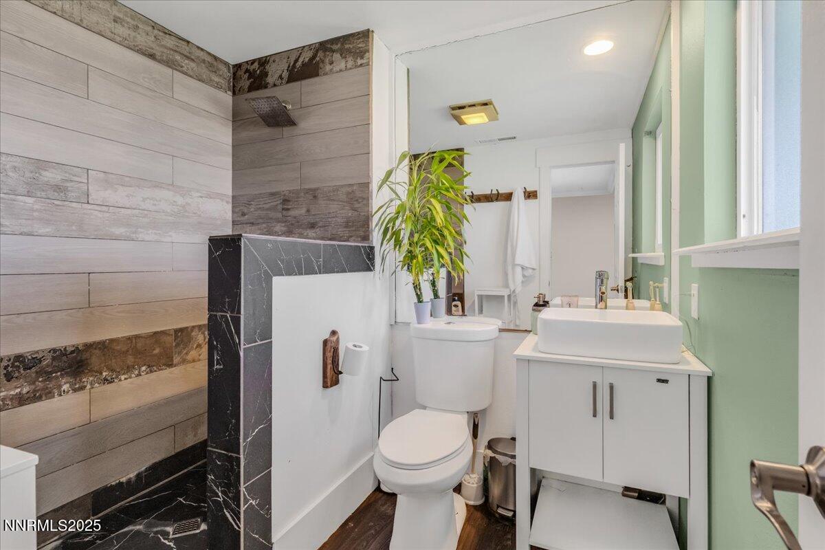 1231 Manhattan Way Gardnerville, NV 89460 - Photo 25 of 45 a bathroom with a sink a toilet and a mirror