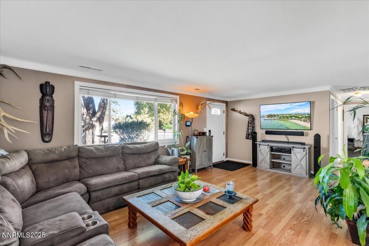 1231 Manhattan Way Gardnerville, NV 89460 - Photo 6 of 45 a living room with furniture a flat screen tv and a floor to ceiling window