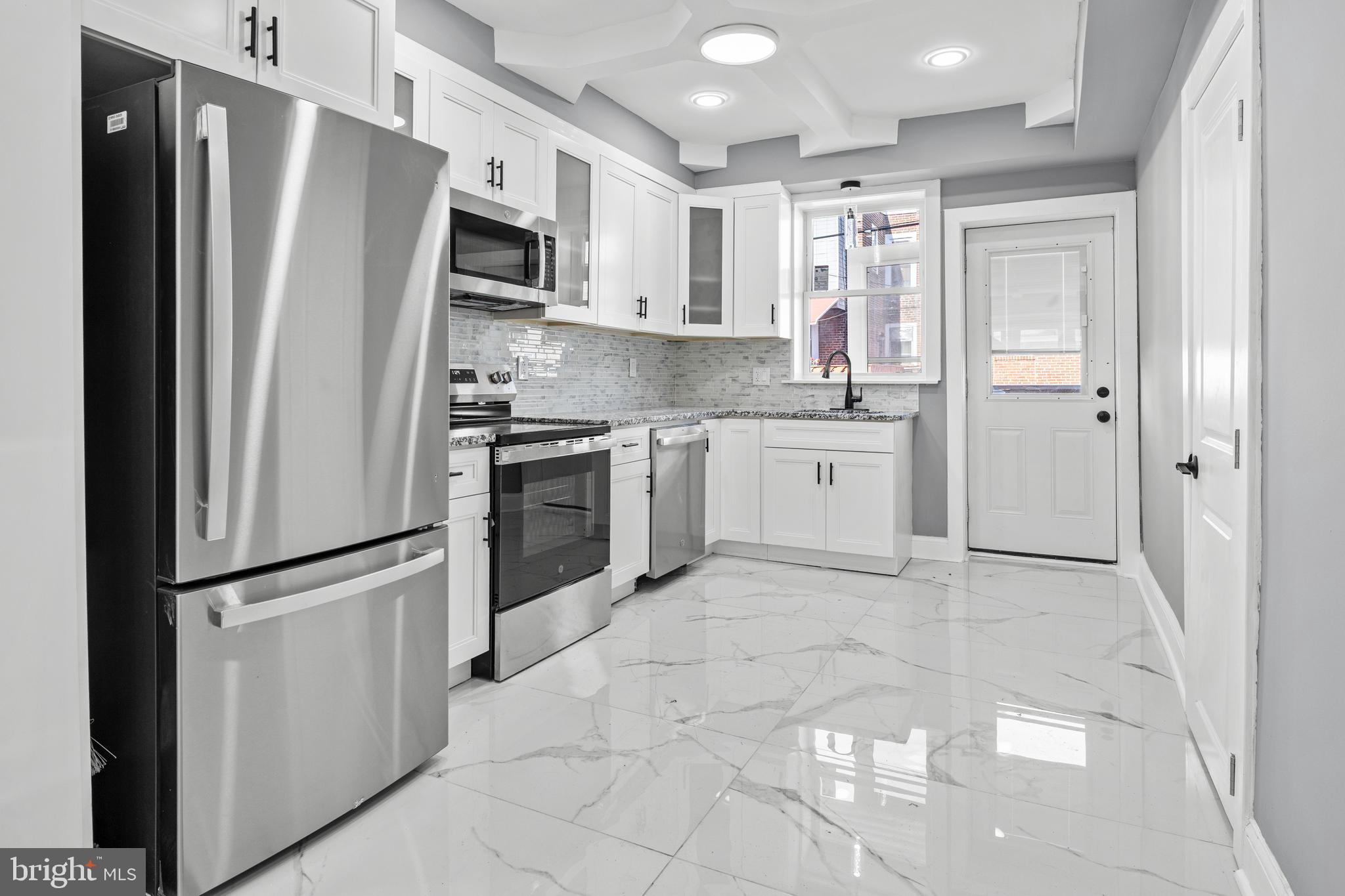 a kitchen with stainless steel appliances granite countertop a refrigerator and a stove top oven