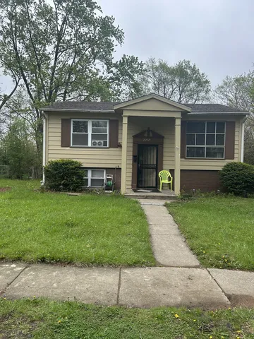 a front view of a house with a garden and yard