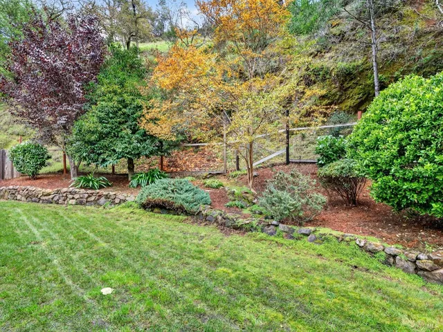 an aerial view of a house with a yard and mountain