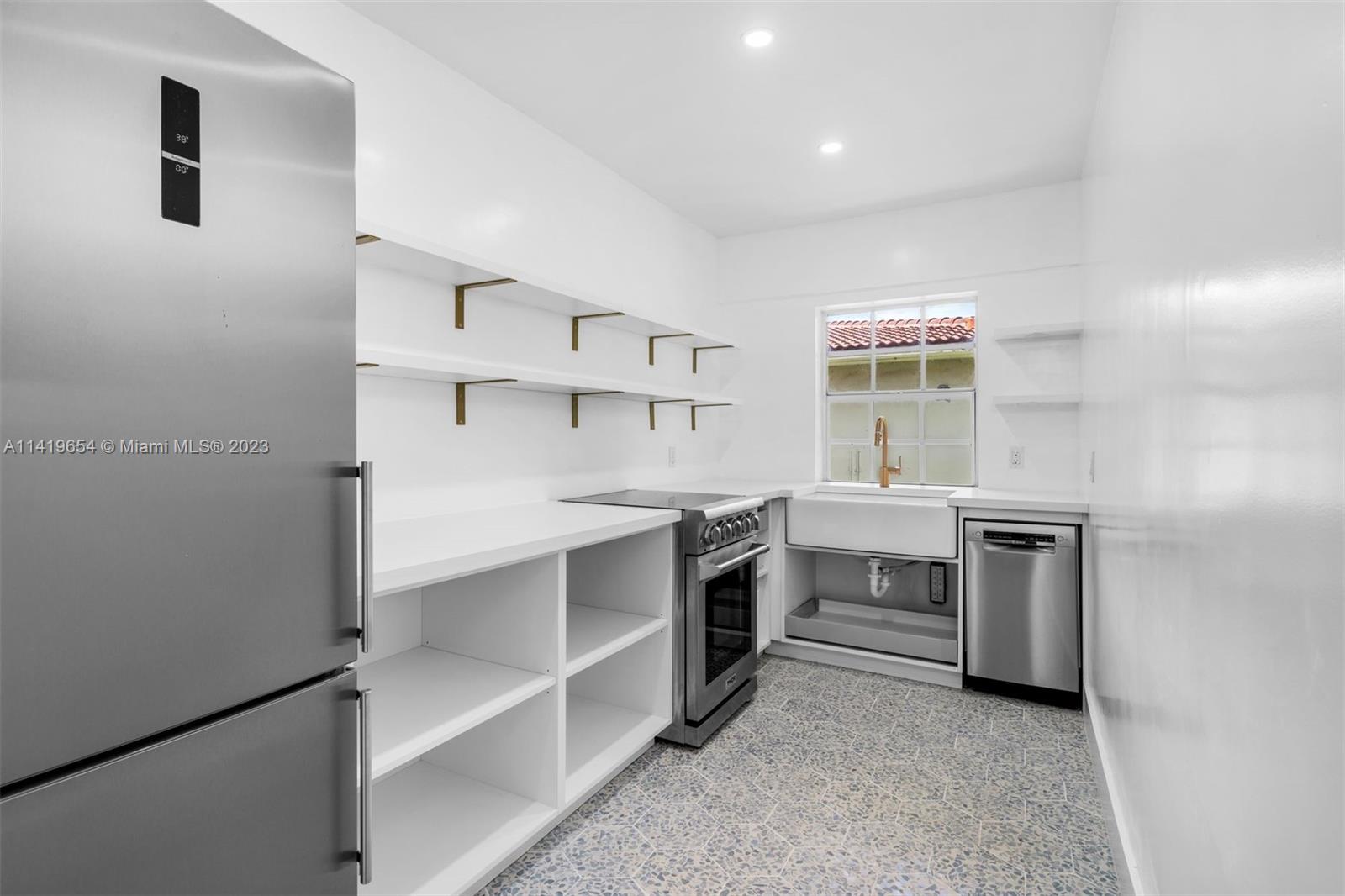 60 Park Drive, Unit D Bal Harbour, FL 33154 - Photo 3 of 11 a kitchen with white cabinets and appliances