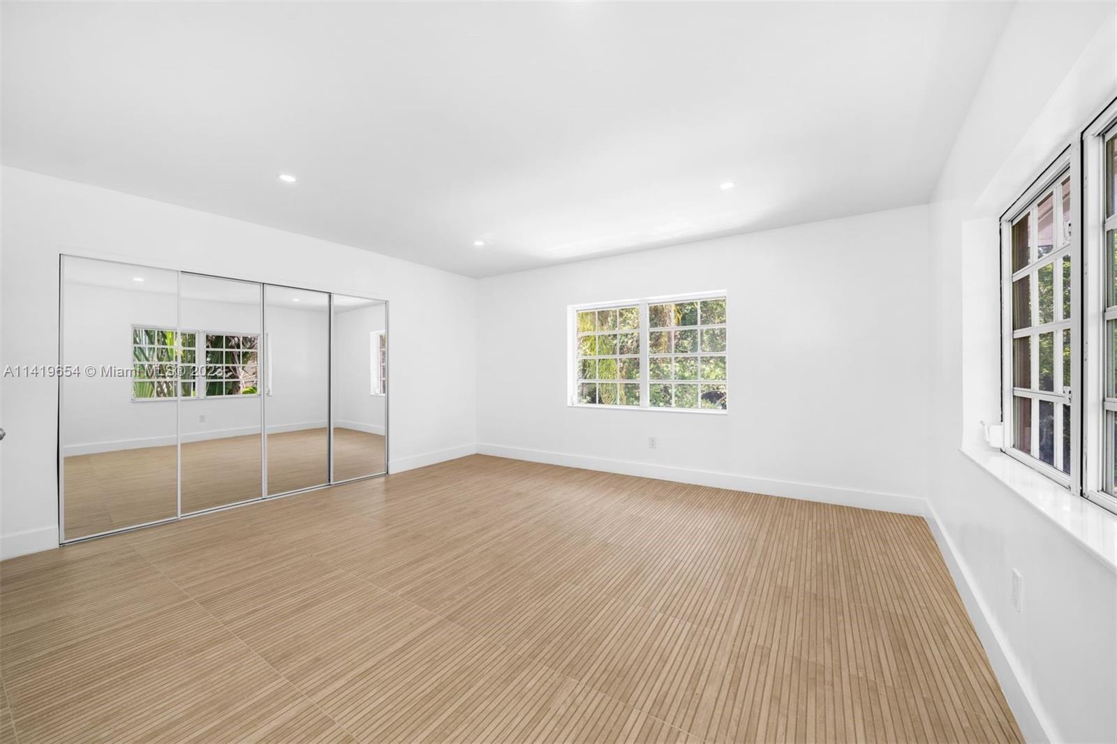 60 Park Drive, Unit D Bal Harbour, FL 33154 - Photo 4 of 11 an empty room with wooden floor and windows