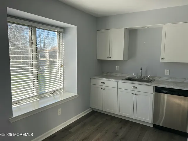 a room with granite countertop cabinets sink and window