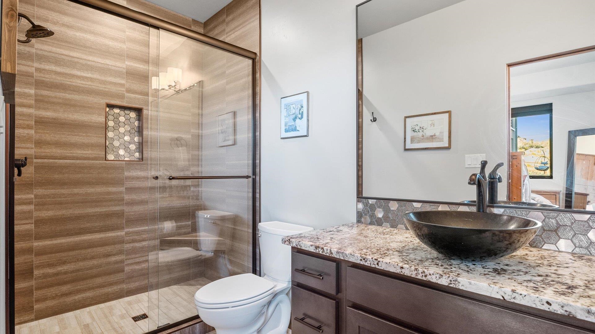 379 High Desert Road Grand Junction, CO 81507 - Photo 27 of 42 a bathroom with a granite countertop sink a toilet a mirror and shower