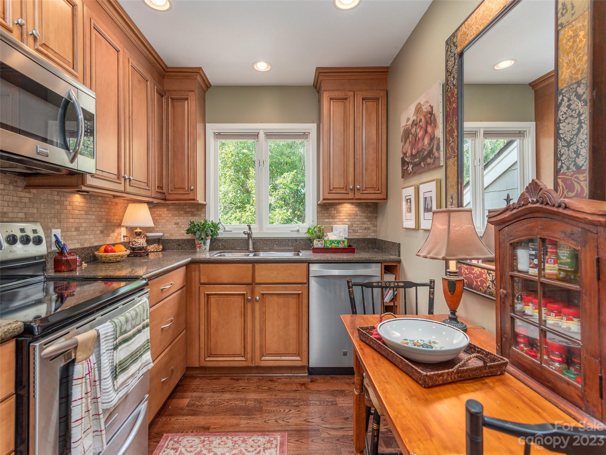 106 Beaver Ridge Road Asheville, NC 28804 - Photo 9 of 19 a kitchen with stainless steel appliances granite countertop a stove top oven a sink dishwasher and cabinets with wooden floor