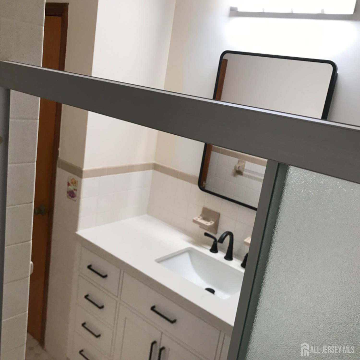 354 Alpine Street Perth Amboy, NJ 08861 - Photo 16 of 16 a bathroom with a sink and mirror