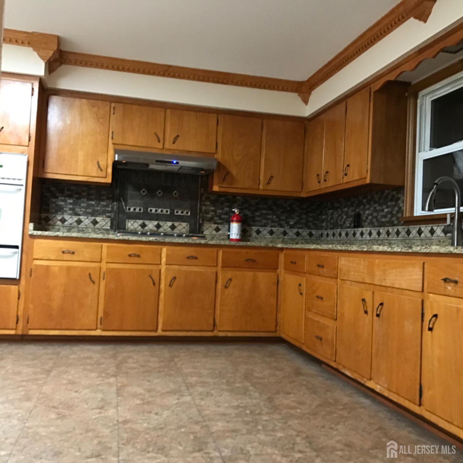 354 Alpine Street Perth Amboy, NJ 08861 - Photo 4 of 16 a kitchen with granite countertop a sink a stove and cabinets