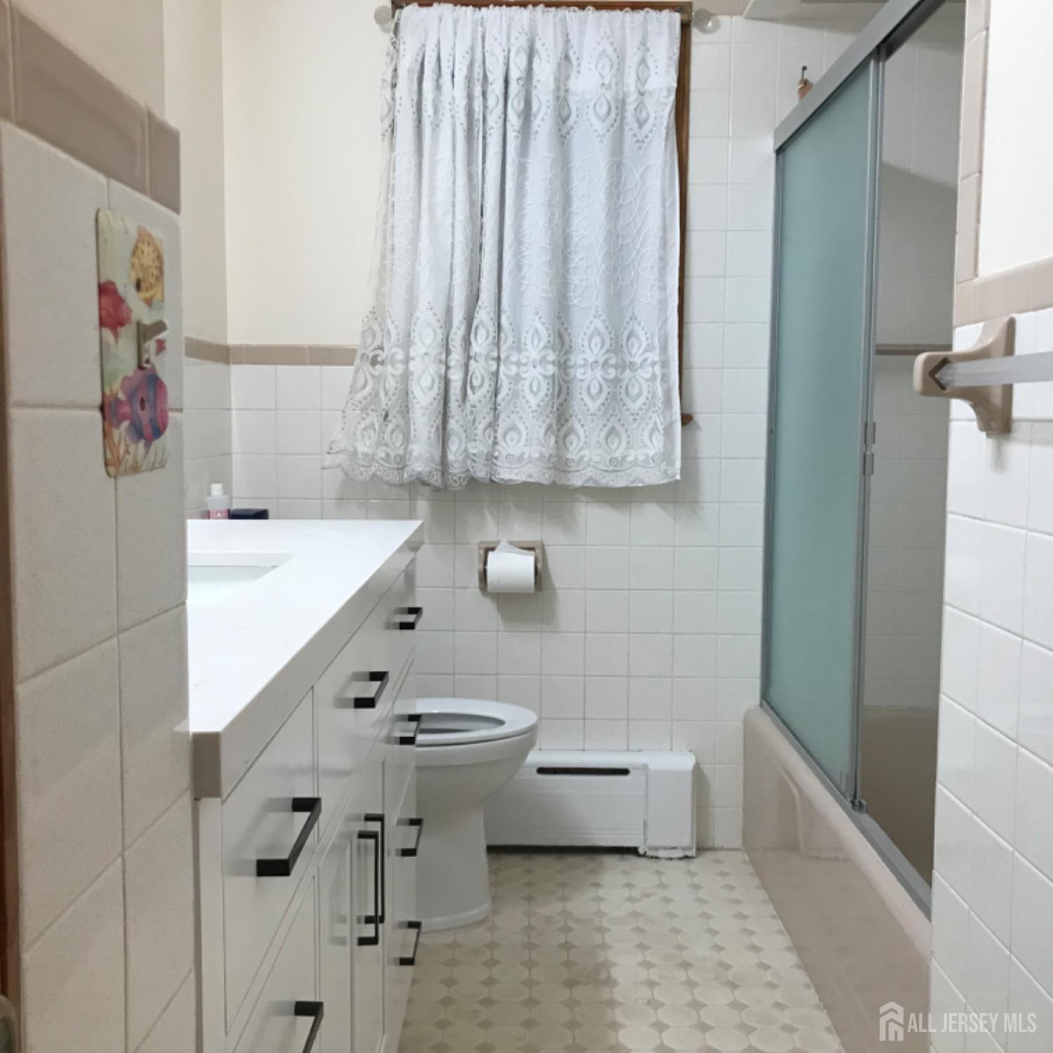 354 Alpine Street Perth Amboy, NJ 08861 - Photo 7 of 16 a bathroom with a sink a toilet and bathtub