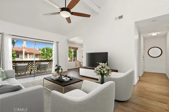 a living room with furniture potted plant and a large window