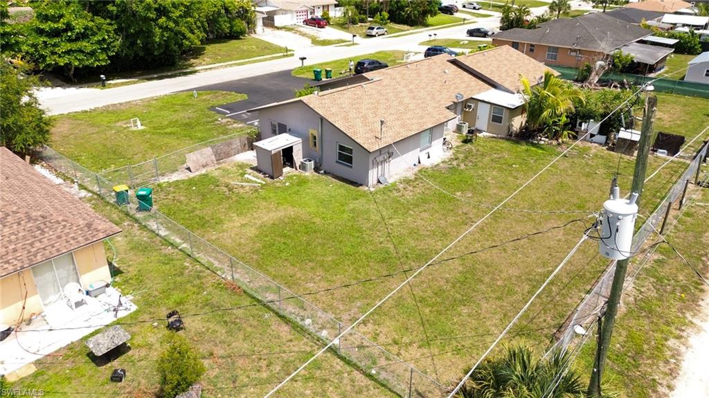 1940 48th Street Southwest Naples, FL 34116 - Photo 10 of 33 Expansive lot featuring a chain-link fence, mature trees, and a detached shed