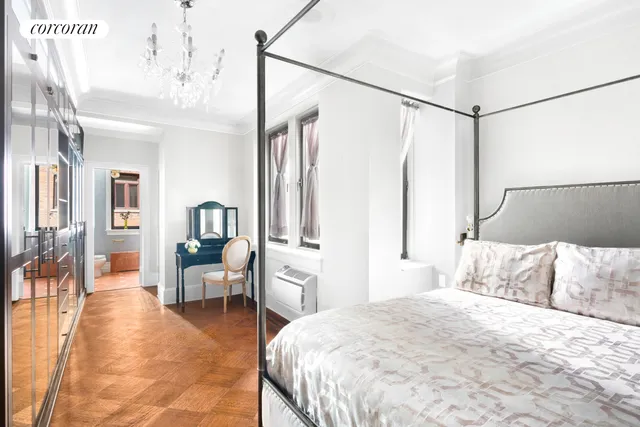 a bedroom with a large bed and a chandelier