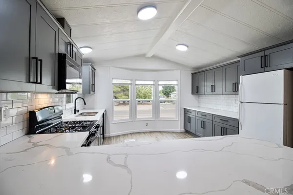 a kitchen with stainless steel appliances granite countertop a sink and stove top oven