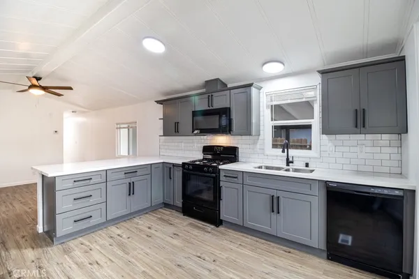 a kitchen with stainless steel appliances kitchen island hardwood floor stove sink and cabinets