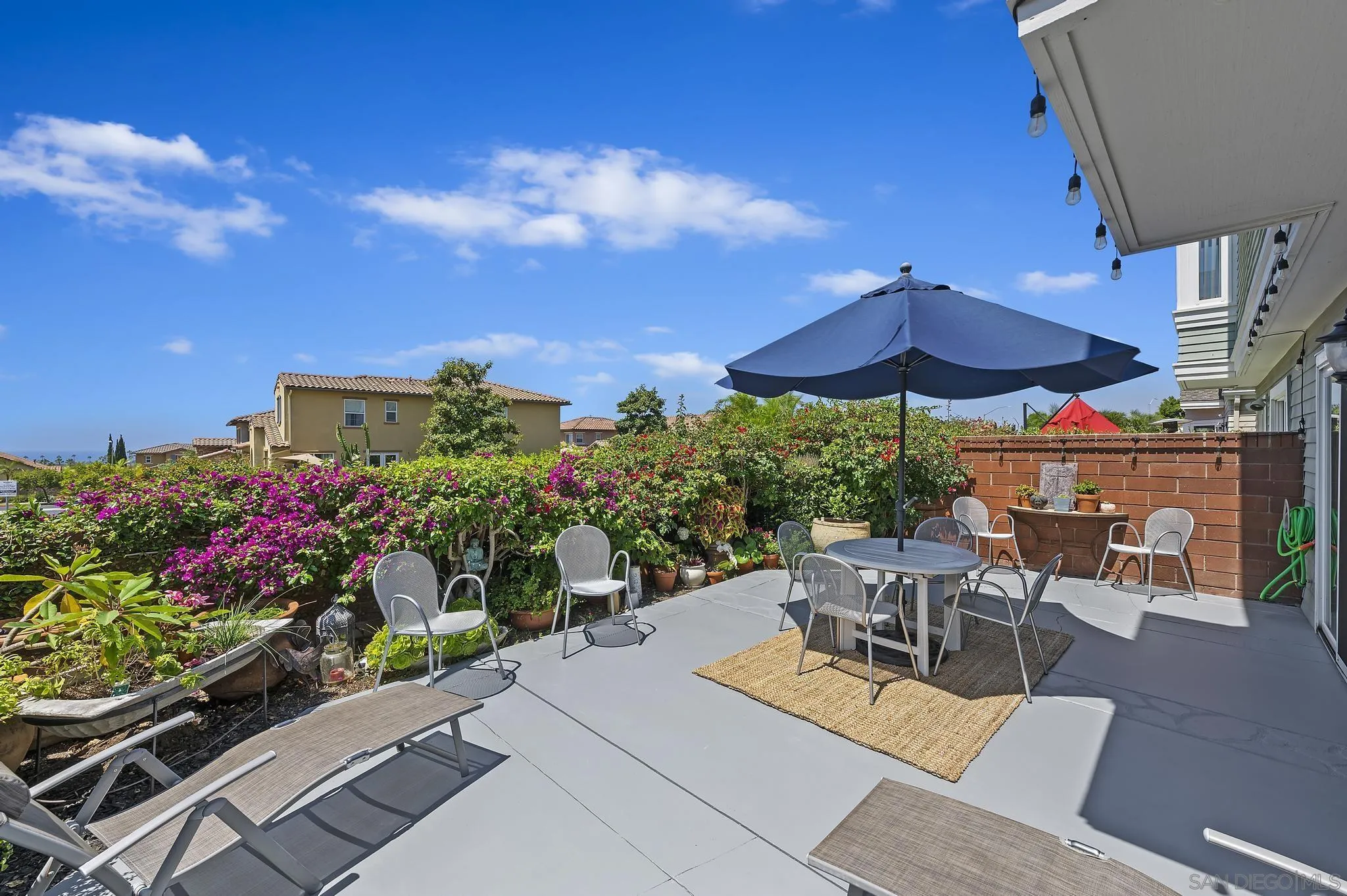 7015 Lavender Way Carlsbad, CA 92011 - Photo 31 of 67 a view of a patio with a table and chairs under an umbrella