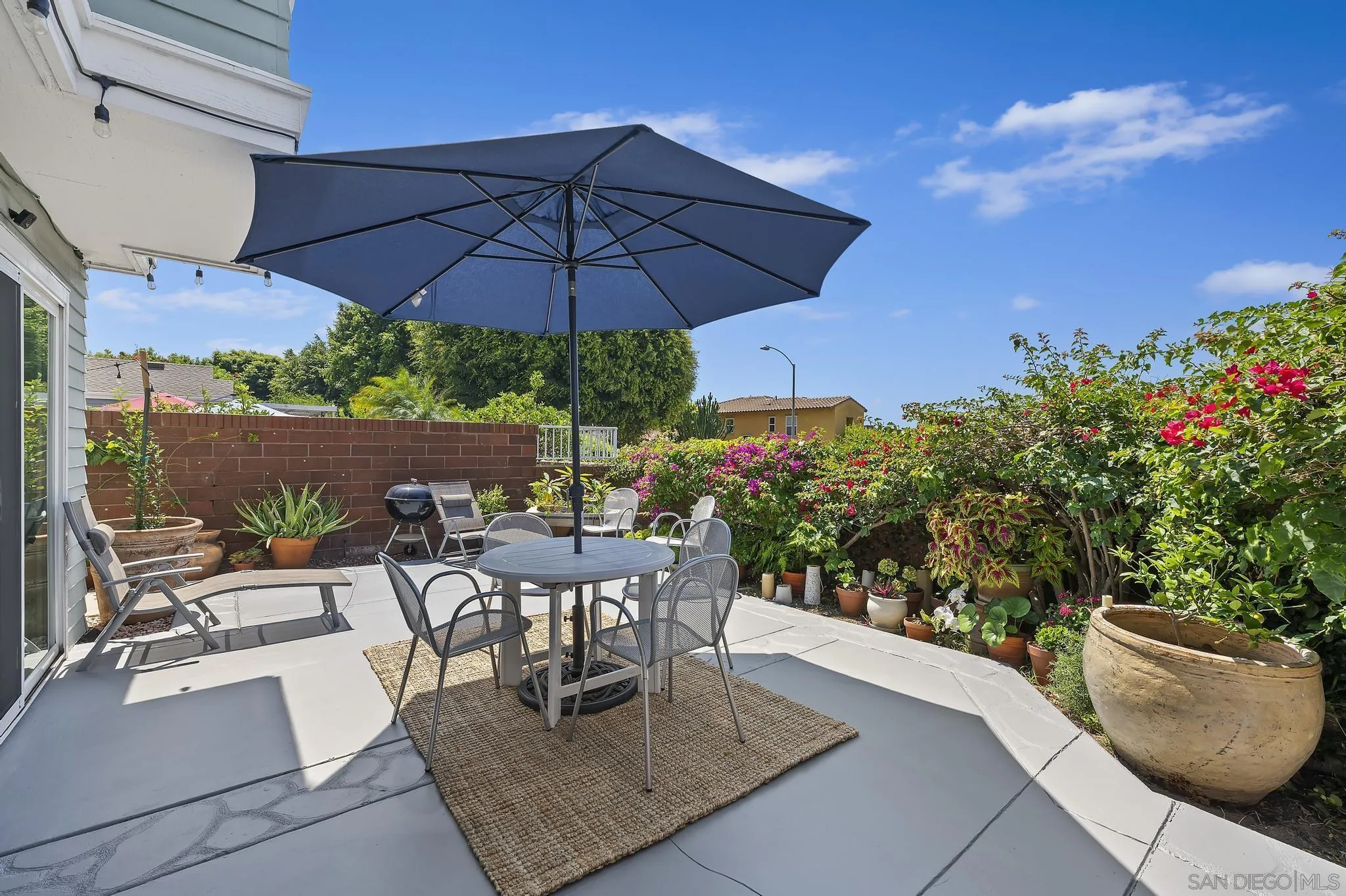 7015 Lavender Way Carlsbad, CA 92011 - Photo 33 of 67 a view of a patio with couches table and chairs under an umbrella