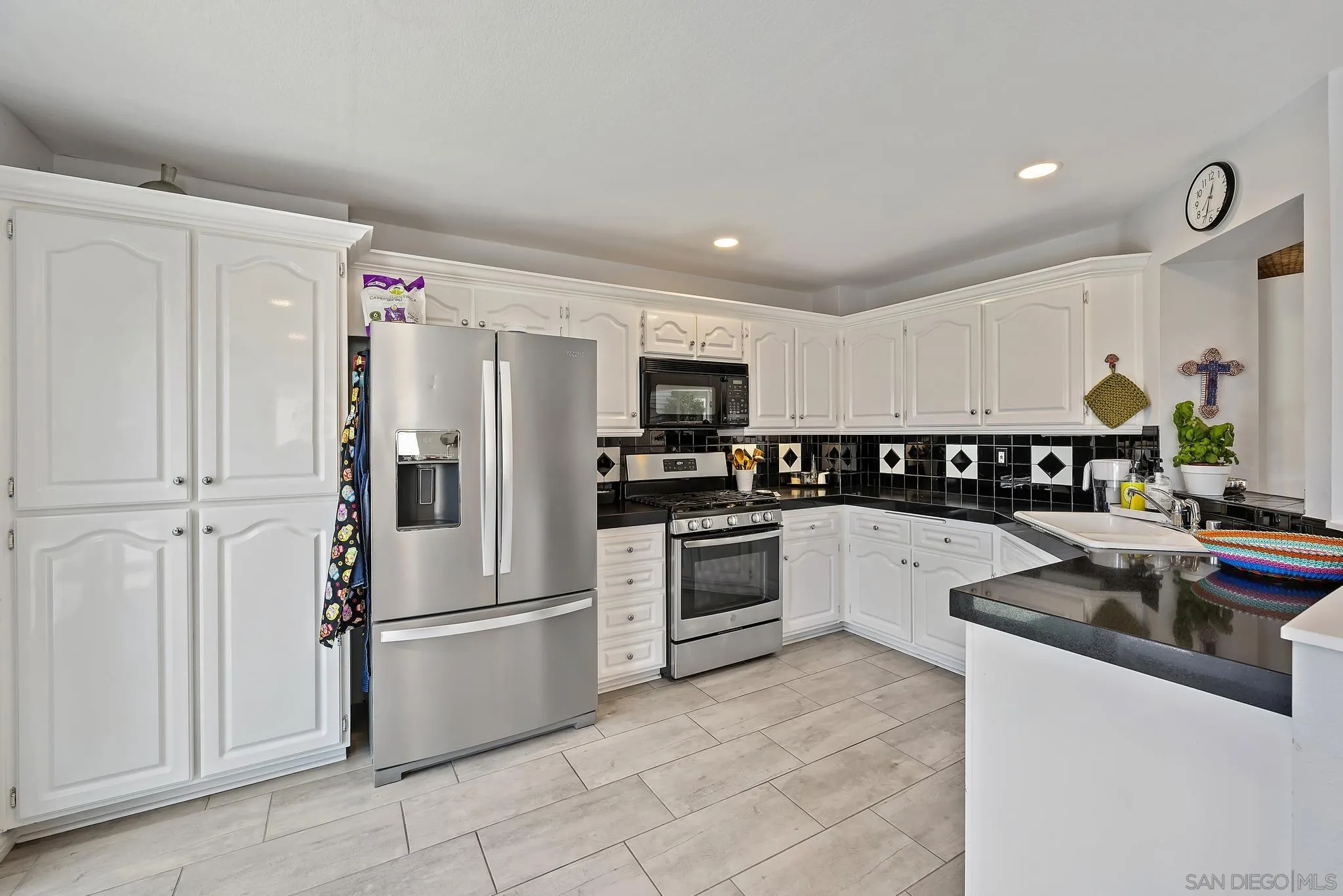 7015 Lavender Way Carlsbad, CA 92011 - Photo 10 of 67 a kitchen with granite countertop a refrigerator stove top oven and sink
