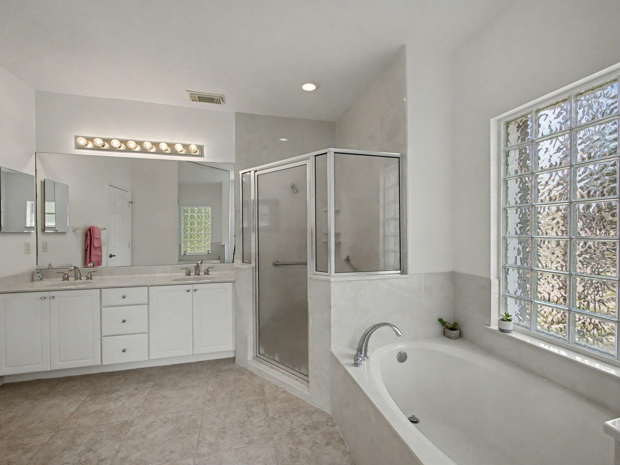 8122 Southwest Yachtsmans Drive Stuart, FL 34997 - Photo 22 of 43 a bathroom with a bathtub a sink a mirror a shower and vanity
