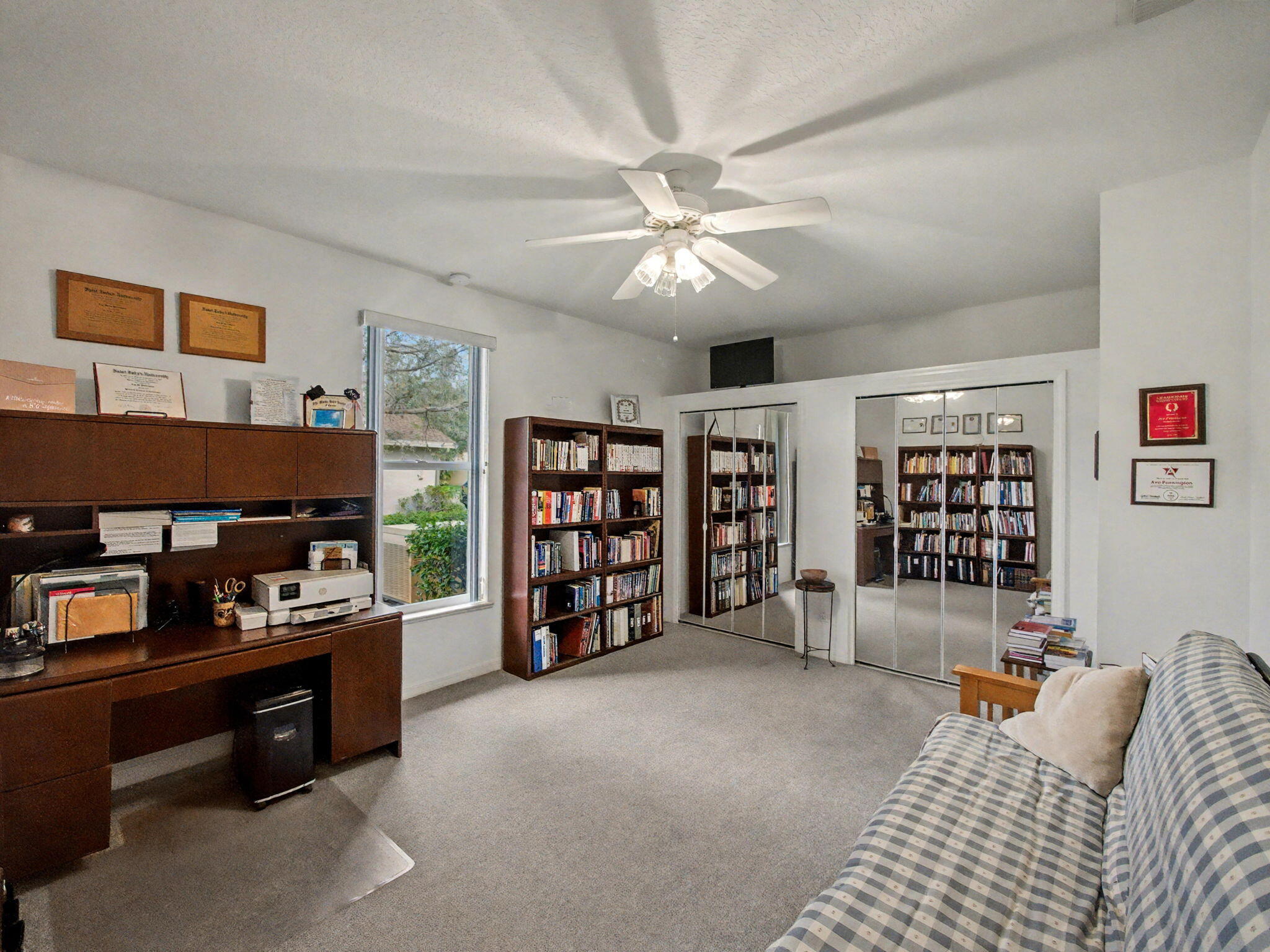 8122 Southwest Yachtsmans Drive Stuart, FL 34997 - Photo 23 of 43 a living room with furniture a ceiling fan and a book shelf