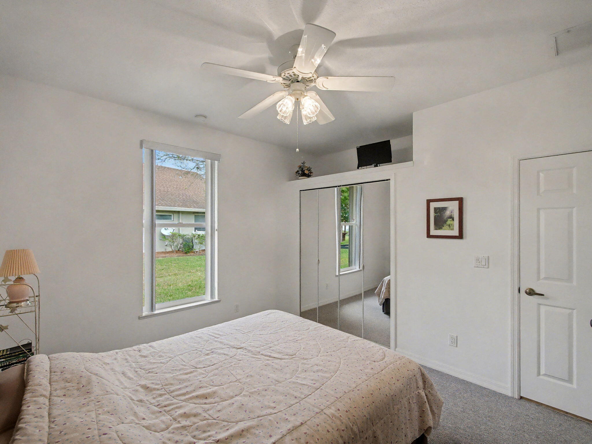 8122 Southwest Yachtsmans Drive Stuart, FL 34997 - Photo 26 of 43 a bedroom with a large bed and a chandelier