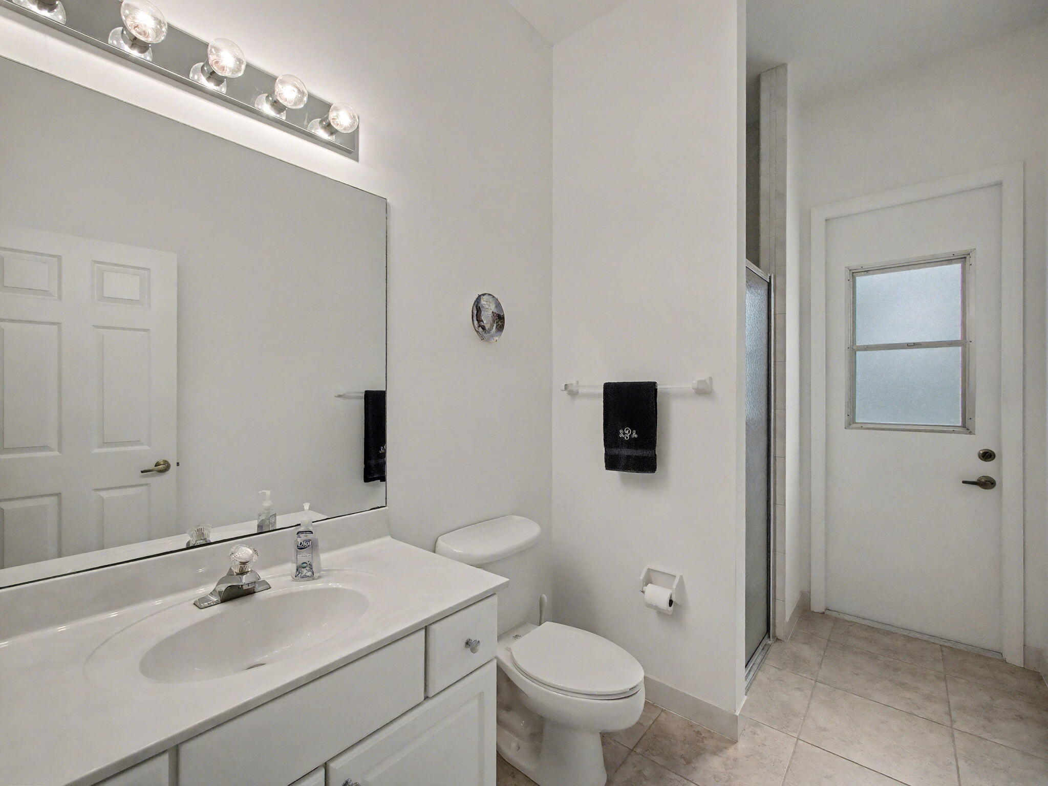 8122 Southwest Yachtsmans Drive Stuart, FL 34997 - Photo 28 of 43 a bathroom with a toilet a sink a mirror and vanity